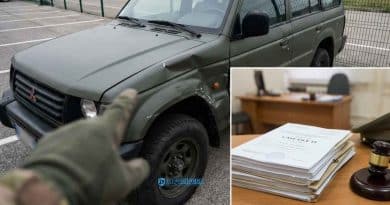 Primo piano di un'auto dei Carabinieri con targa militare danneggiata dopo un incidente stradale durante il servizio.